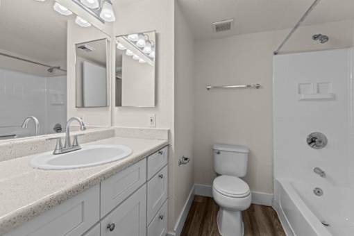 A white bathroom with a sink, toilet, and bathtub.