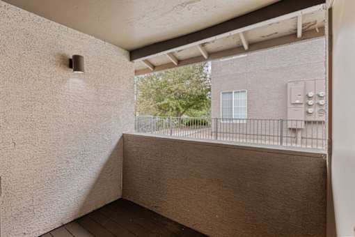 A balcony with a railing and a building in the background.