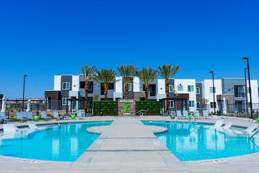 A swimming pool in front of a row of modern houses.