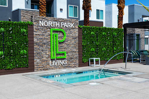 A pool in front of a wall with North Park Living written on it.