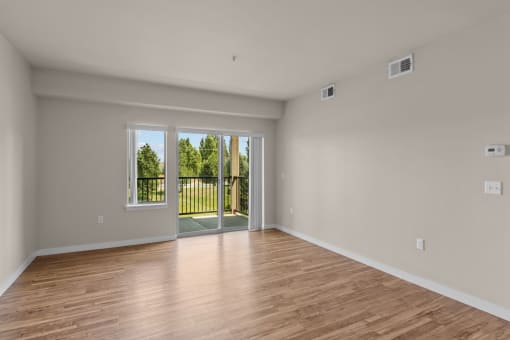 a bedroom with hardwood floors and a sliding glass door to a balcony