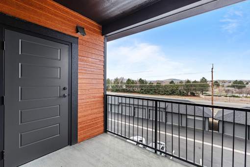 a balcony with a door and a street in the background