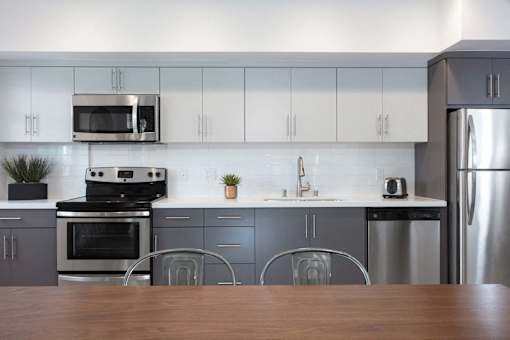 Apartments in Hollywood, CA for Rent - The Fifty Five Fifty - Kitchen with an Open Floor Plan, White Cabinets, and Stainless-Steel Appliances
