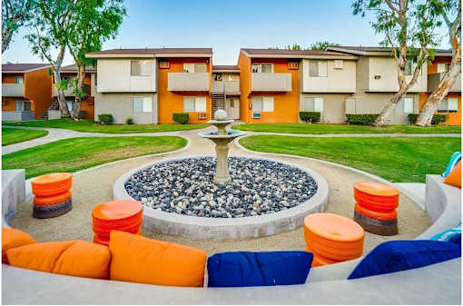 A courtyard with a fountain surrounded by orange and blue seating.