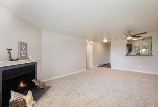 A living room with a fireplace and a carpet.