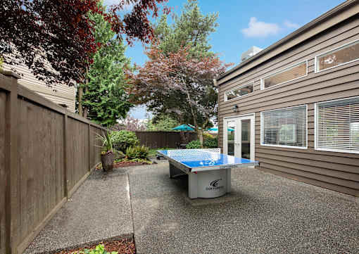 A table tennis table is placed on a concrete patio.
