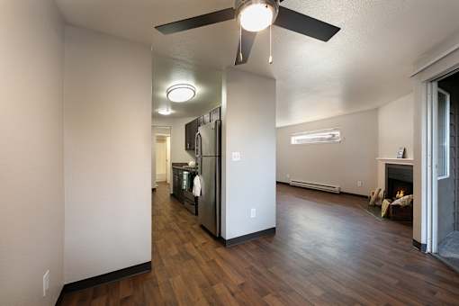 A kitchen with a refrigerator, oven, and a ceiling fan.