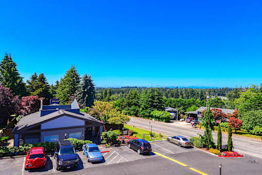 A parking lot with cars and a building in the background.
