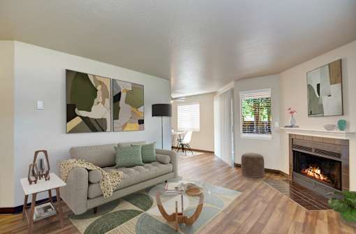 A living room with a grey couch and a fireplace.