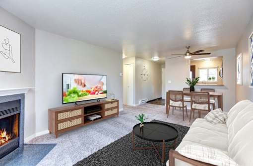 A living room with a fireplace and a television on a wooden stand.