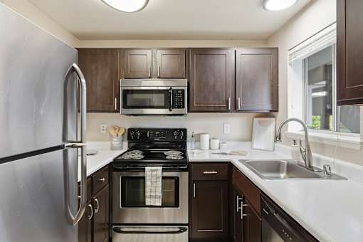 A kitchen with brown cabinets and a black stove top.