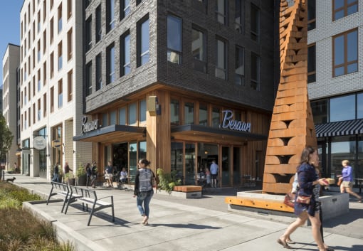 people walking on a sidewalk in front of a building