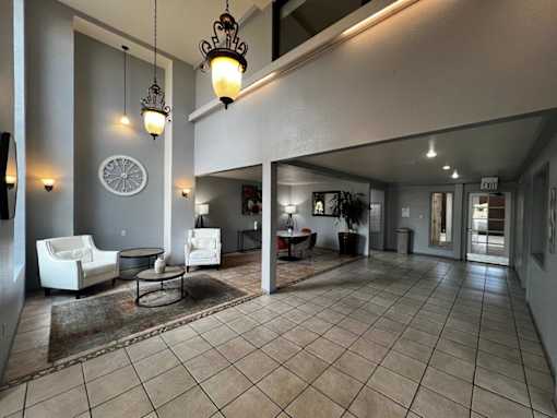 A living room with a white couch and a rug.