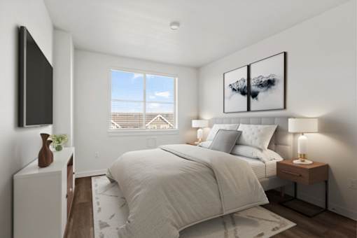 A bedroom with a large bed, a flat screen TV, and a window overlooking a balcony.