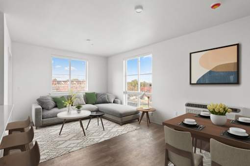 A living room with a grey couch, a coffee table, and a painting on the wall.