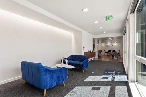 A blue couch is in the middle of a room with a rug and a table.