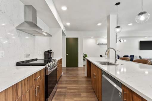 A modern kitchen with wooden cabinets and a marble countertop.