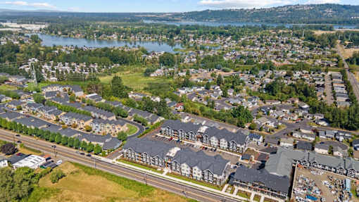 A bird's eye view of a residential area with houses and a lake in the background.