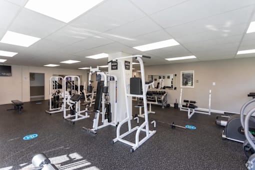 A gym with a variety of equipment including a leg press machine.