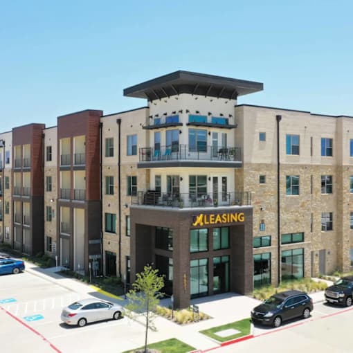 A multi-story building with a leasing office in front.