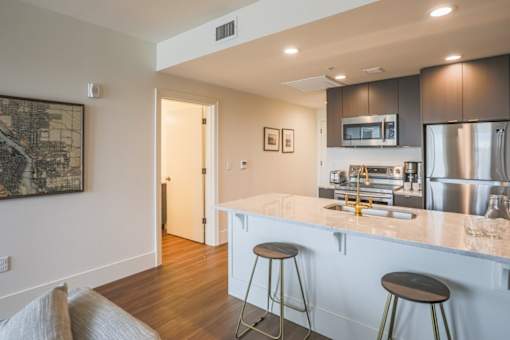 A kitchen with a bar area and a painting on the wall.