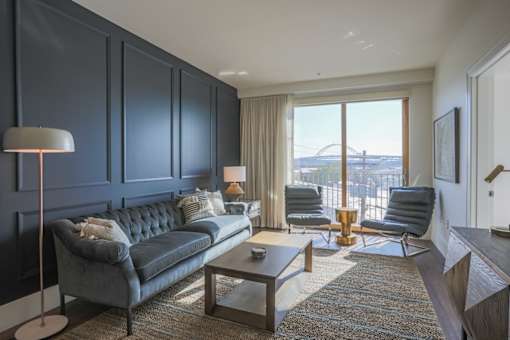 A modern living room with a grey sofa and a glass coffee table.