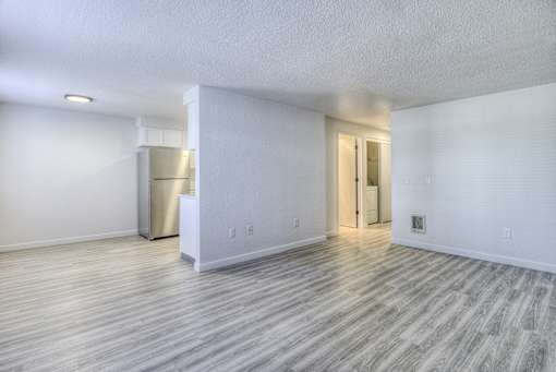 Oasis at 2600 the living room and kitchen of an empty apartment with wood flooring
