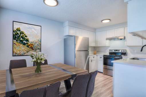 Oasis at 2600 A kitchen with a dining table and chairs.