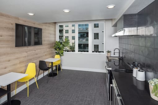 a room with a table and chairs and a television on the wall
