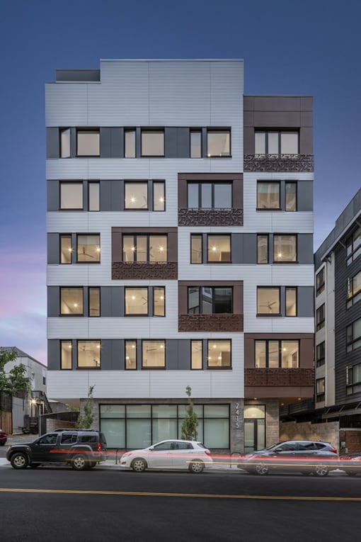 a rendering of an apartment building on a city street with cars parked in front of it