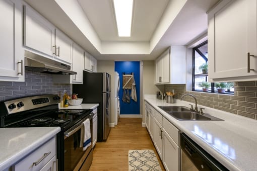 a kitchen with white cabinets and black appliances
