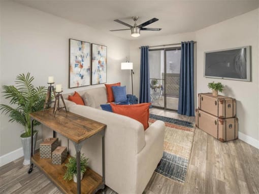 a living room filled with furniture and a ceiling fan