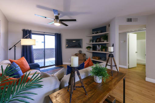a living room with a couch and a table and a ceiling fan