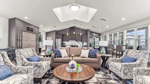 A living room with a brown sofa, two armchairs, and a coffee table.