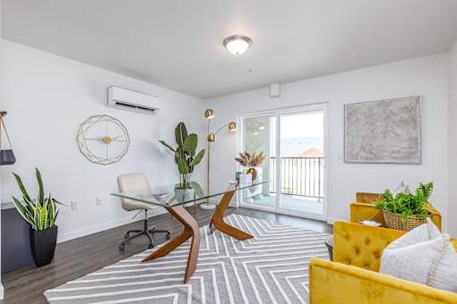 a living room with a glass desk and a yellow couch