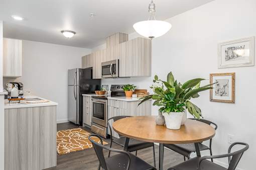 a kitchen and dining area with a table and chairs and a refrigerator