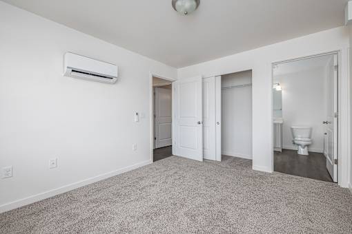 an empty room with a bathroom and a toilet and a closet