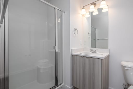 a bathroom with a shower and a sink and a mirror