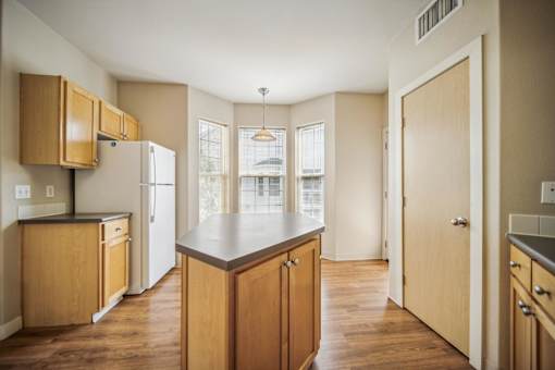 A kitchen with wooden cabinets and a refrigerator.