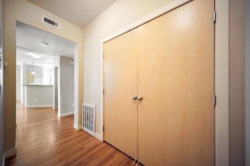 A hallway with a wooden floor and a wooden door.