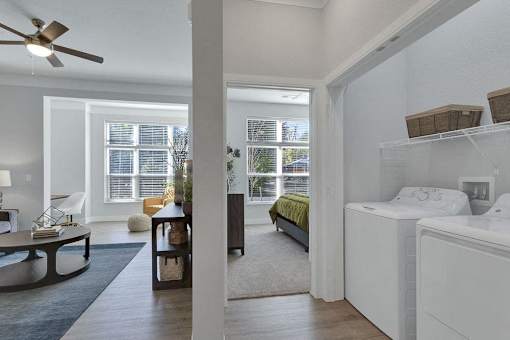 A white bedroom with a ceiling fan and a window with blinds.
