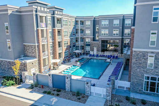 A large apartment complex with a pool in the middle.