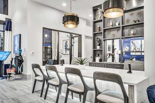 A modern salon with a white counter and grey chairs.