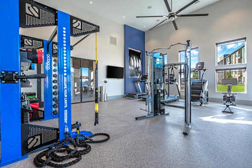 A gym with a variety of equipment including a weight rack, treadmill, and exercise bike.