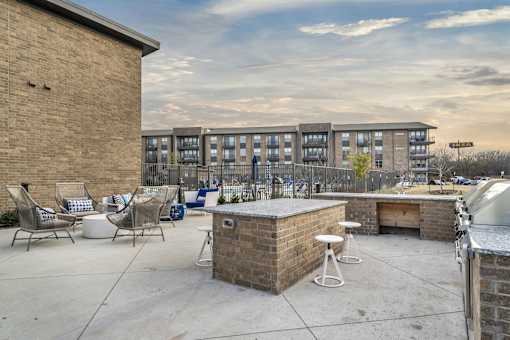 A patio area with a bar and chairs.