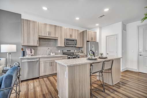 A modern kitchen with wooden cabinets and a central island.