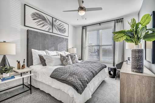 A bedroom with a large bed and a ceiling fan.