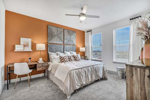 A bedroom with a bed, desk, and chair.