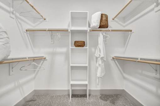 A white closet with a shelf and a basket on top.