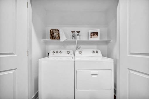 A white washing machine and dryer in a small laundry room.